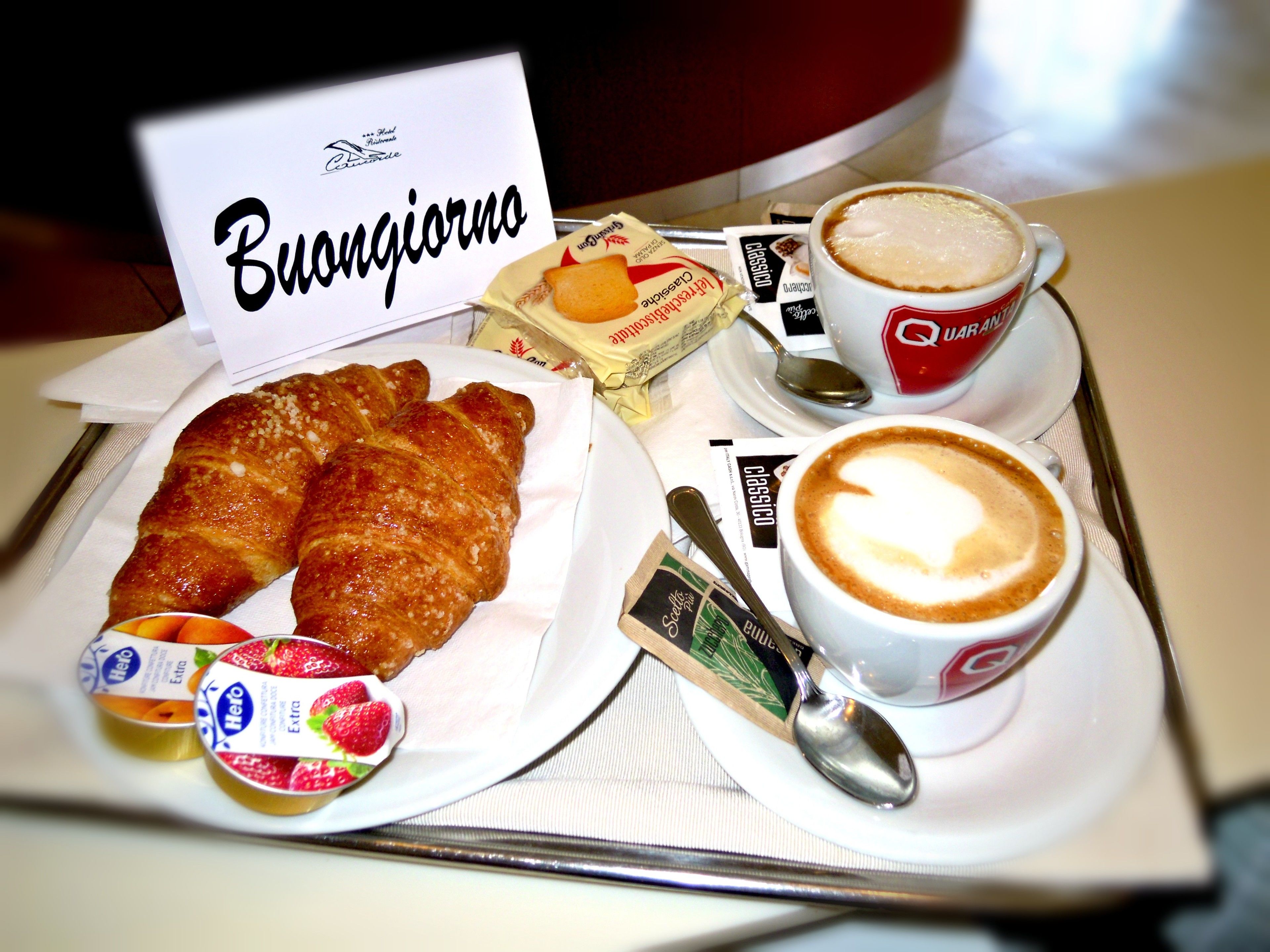 Ein Frühstücksbrett mit Croissants, Kaffee und Joghurt-Parfaits.