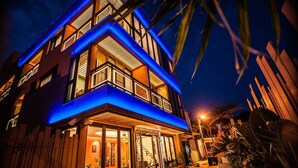 A modern multi-story building with a prominent balcony and large windows. - Dreamer Boutique Hotel (Hengchun)