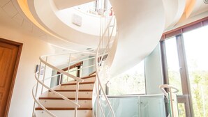 A spiral staircase with a glass railing, leading to an upper floor. - Dreamer Boutique Hotel (Hengchun)