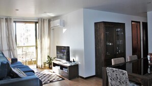 Ein modernes Wohnzimmer mit einer Couch, einem Fernseher und einem Schrank.