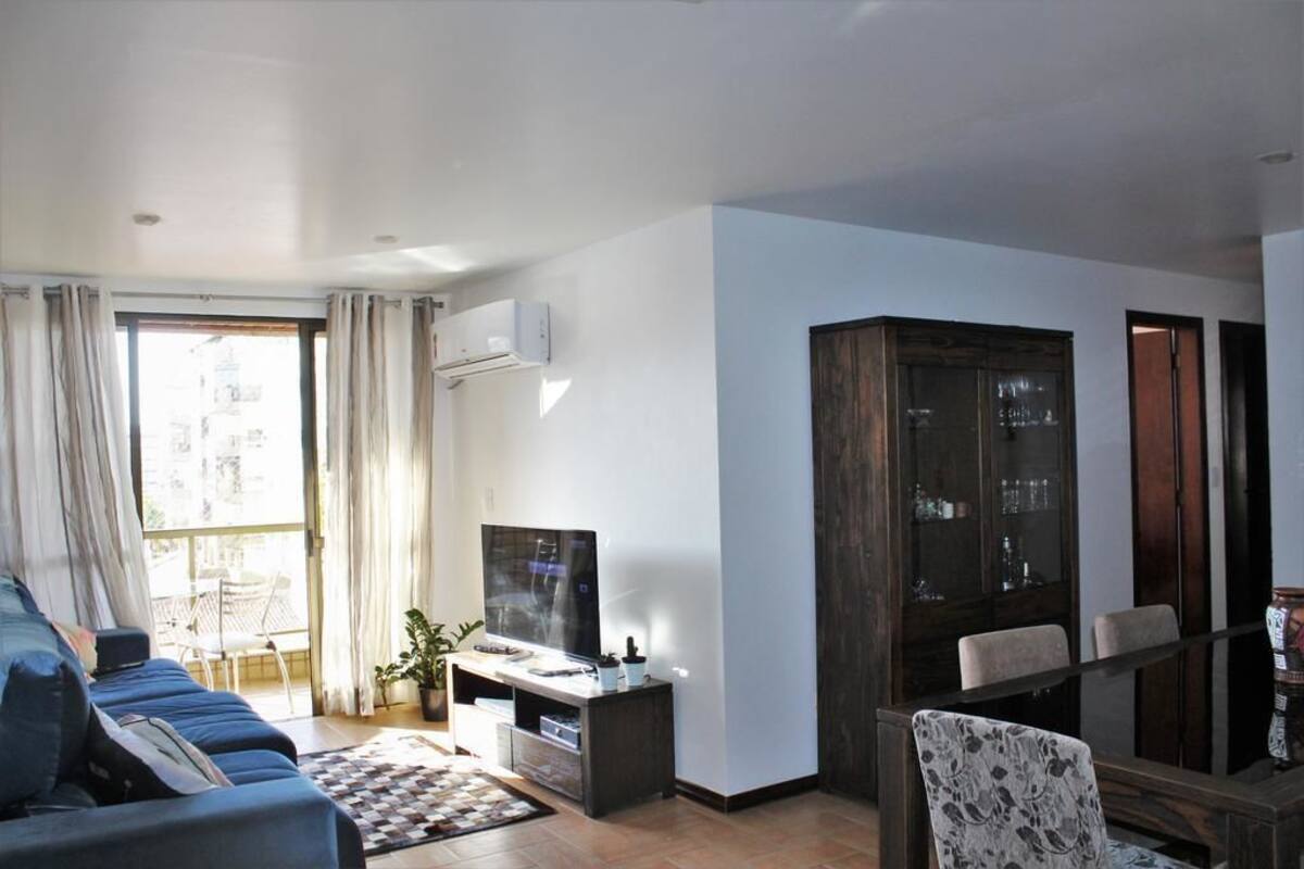 A modern living room with a sofa, TV, and a cabinet.