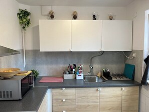 Een koelkast, een microgolfoven, kookgerei, borden en bestek