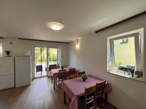 Een koelkast, een microgolfoven, kookgerei, borden en bestek