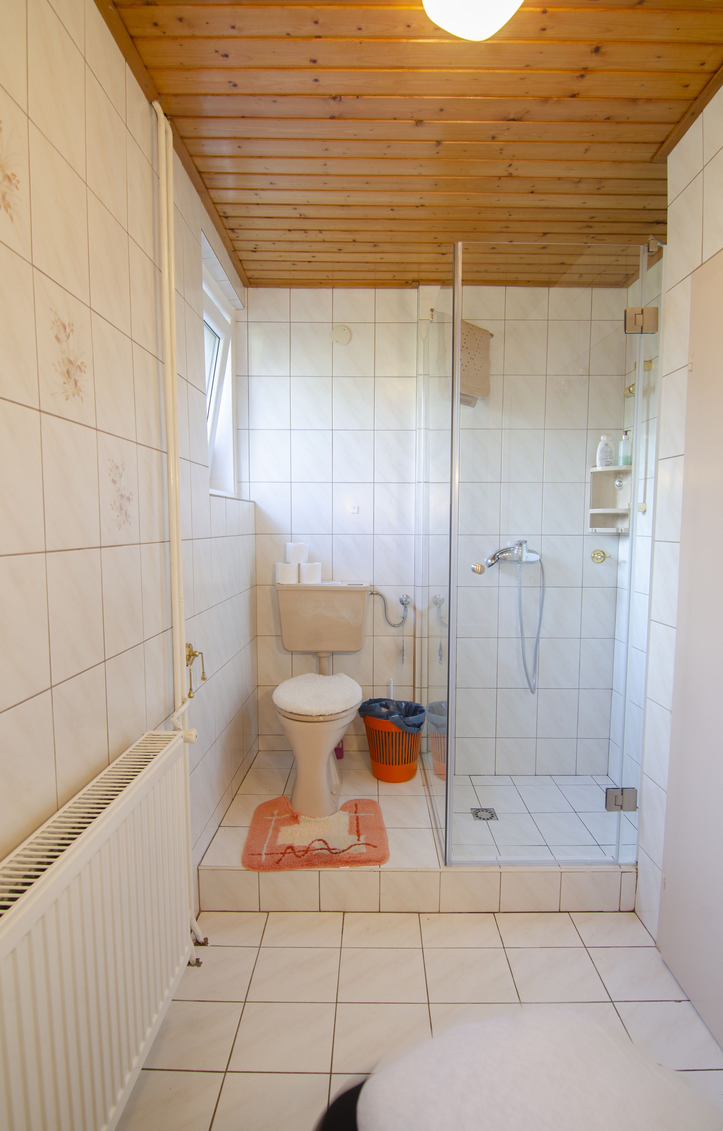 A small bathroom with a toilet, sink, and shower.