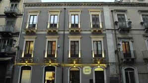 A multi-story building with a classic architectural style, featuring arched windows and balconies. - Etnea 454   Catania Luxury Rooms (Catania)