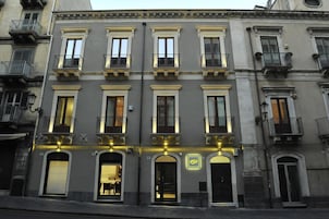 A multi-story building with a classic architectural style, featuring arched windows and balconies.