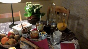 Una mesa de comedor dispuesta con diversos alimentos, una vela y una lámpara.