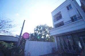 A building with a balcony and a stop sign in front.