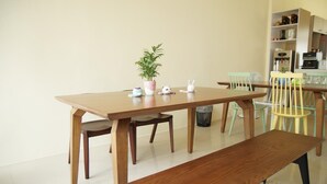 A wooden dining table with chairs, a bench, and a potted plant. - Man Lu B&B (Hualien City)