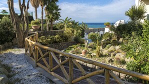 A garden with a wooden railing, various plants, and a view of the sea. - Hotel Terme Tritone Resort & Spa (Forio)