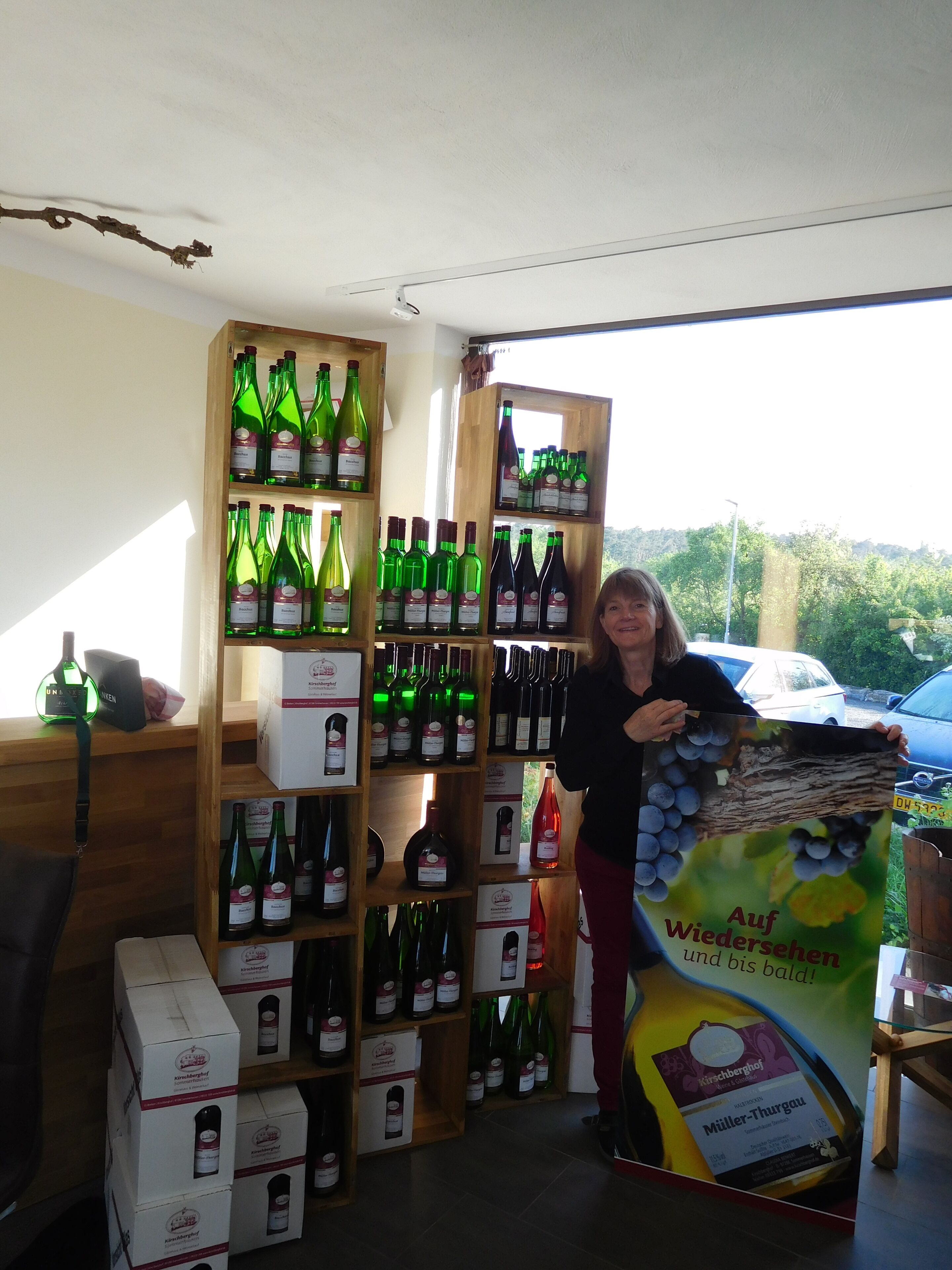 A wine shop with shelves of wine bottles and a large poster advertising a wine.