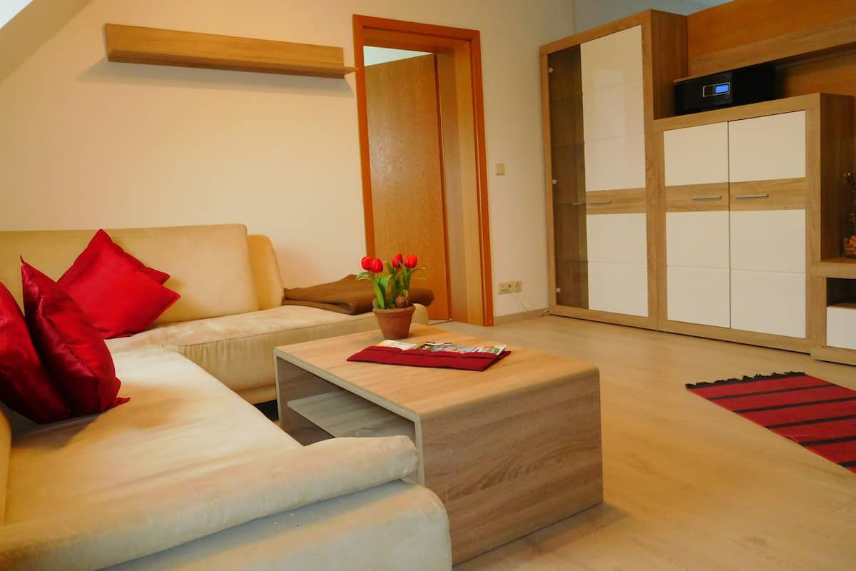 A modern living room with a sofa, a coffee table, a potted plant, and a wardrobe.