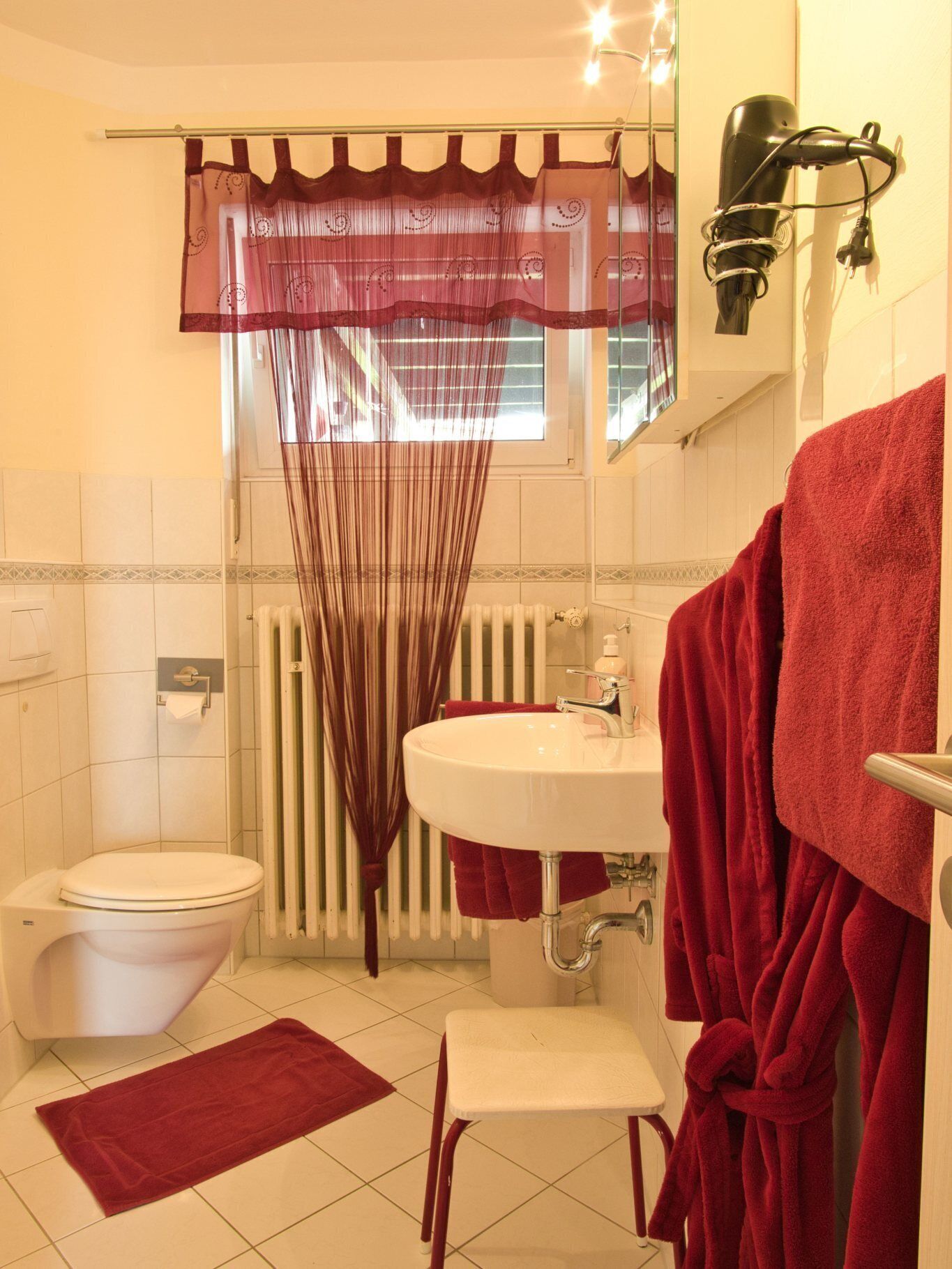 Uma casa de banho com sanita, lavatório e zona de duche.