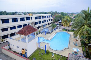 Un hotel con piscina, zona techada y vistas del barrio circundante.