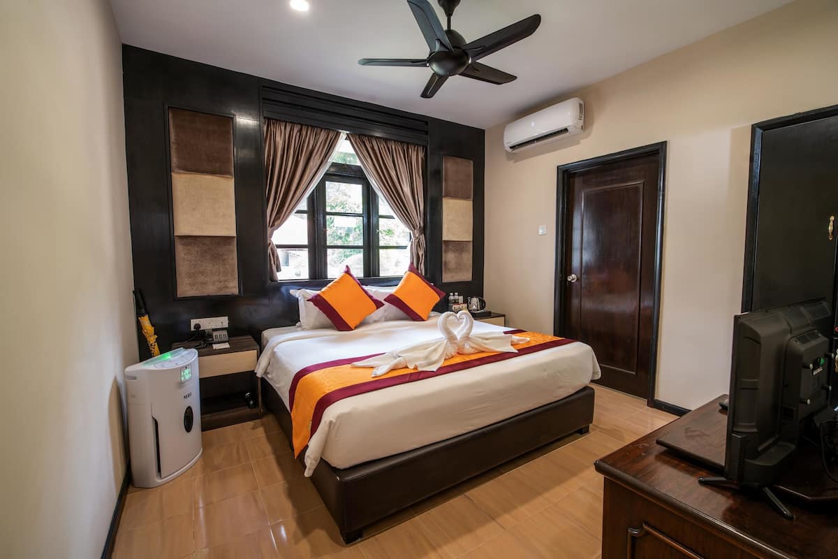 Deluxe King Room, Garden View | Minibar, in-room safe, desk, blackout drapes