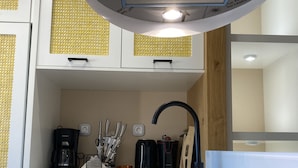 Een moderne keuken met een inbouwfornuis, een spoelbak en een koffiezetapparaat.