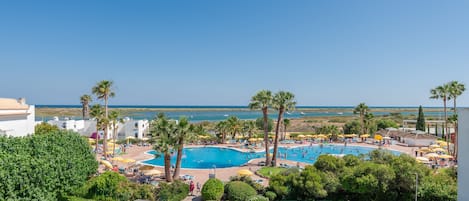 Una piscina techada, 2 piscinas al aire libre, sombrillas