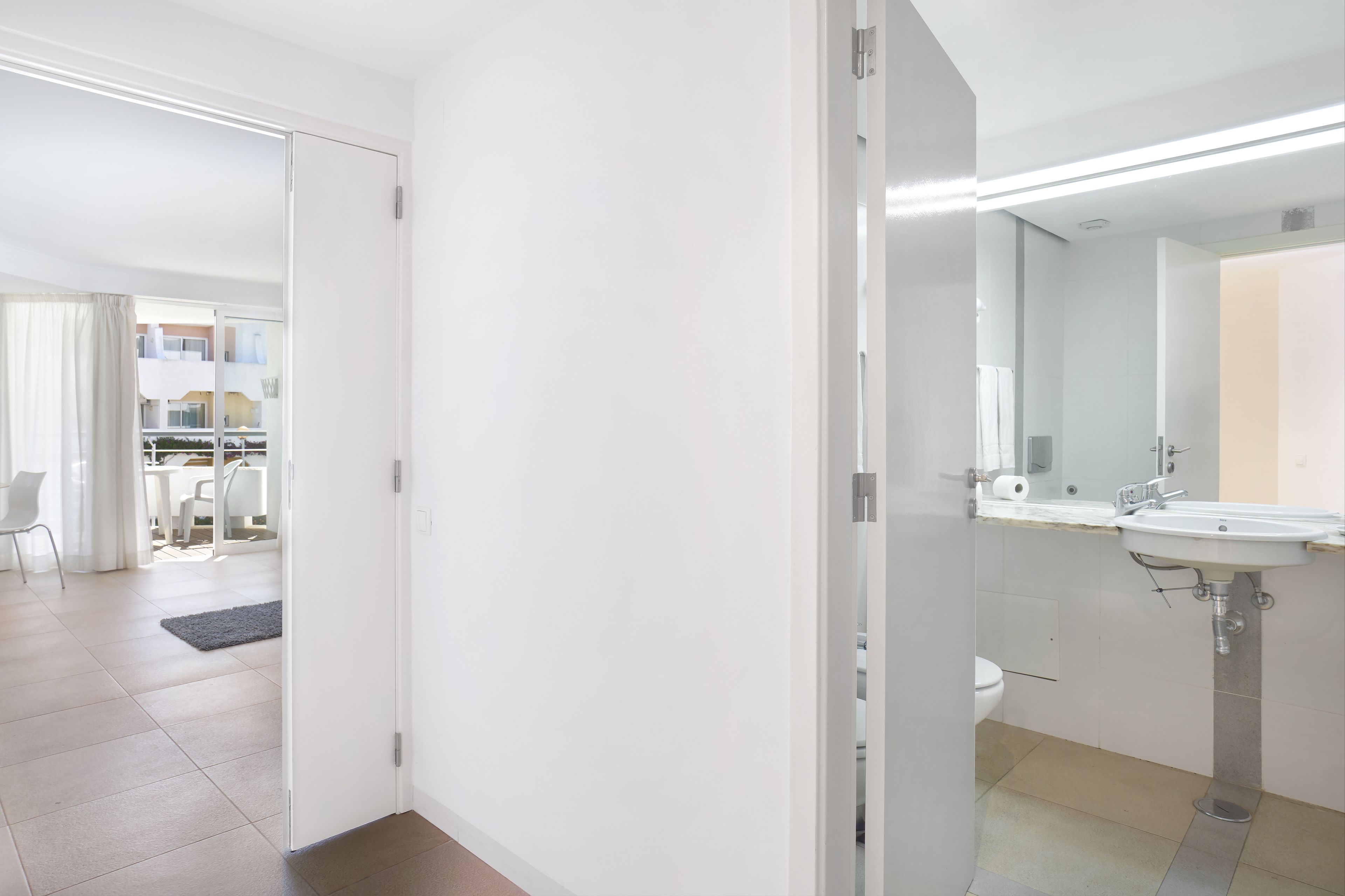 A modern bathroom with a sink, mirror, and toilet.