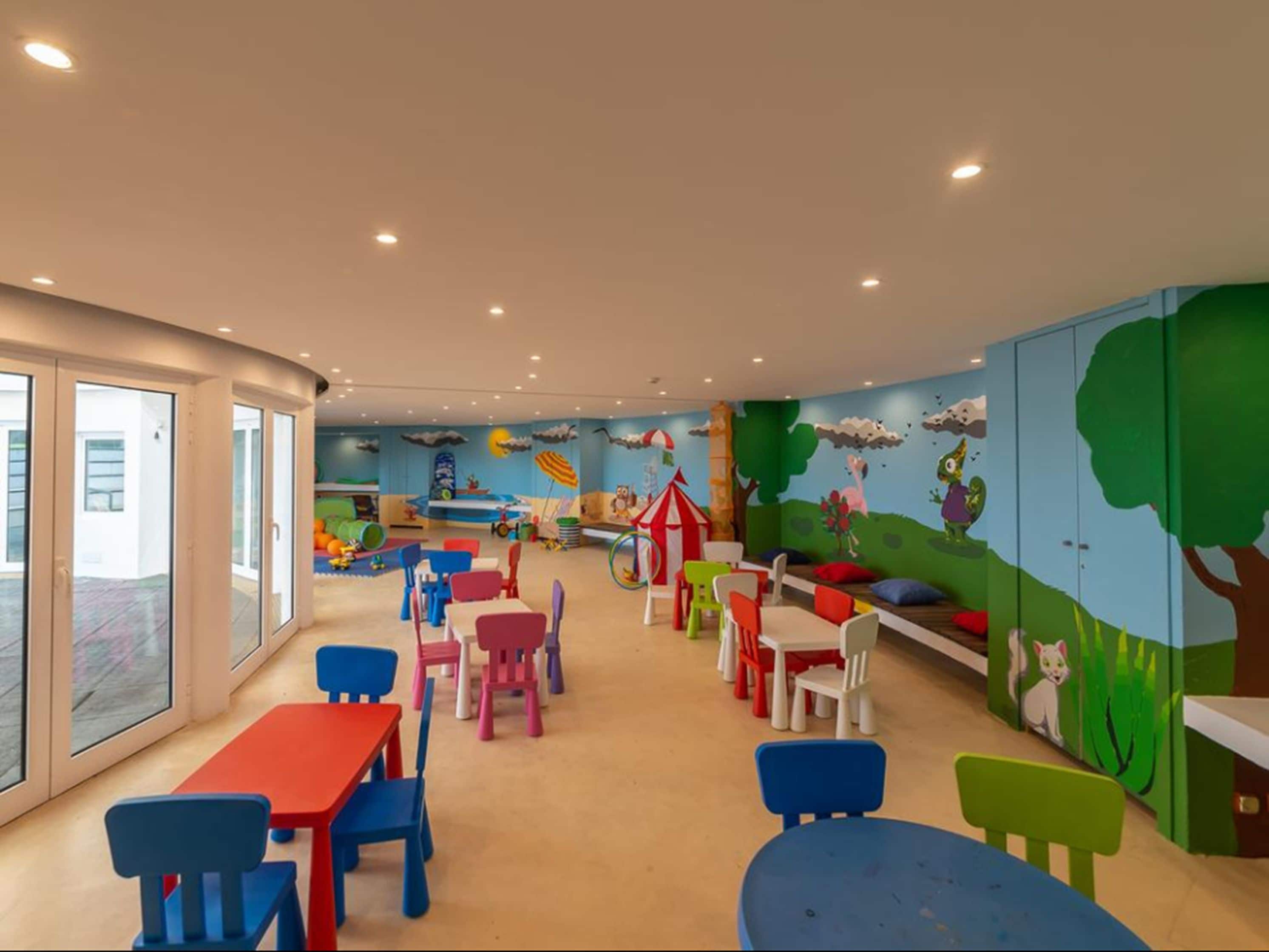 A children's playroom with colorful furniture and murals.