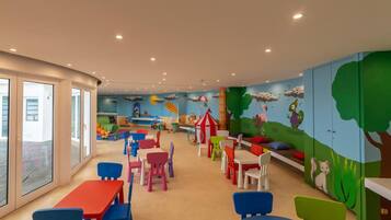 A children's playroom with colorful furniture and murals.