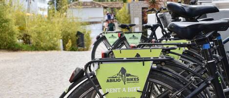 A row of bicycles with 'Rent a Bike' signs, indicating a bike rental service.