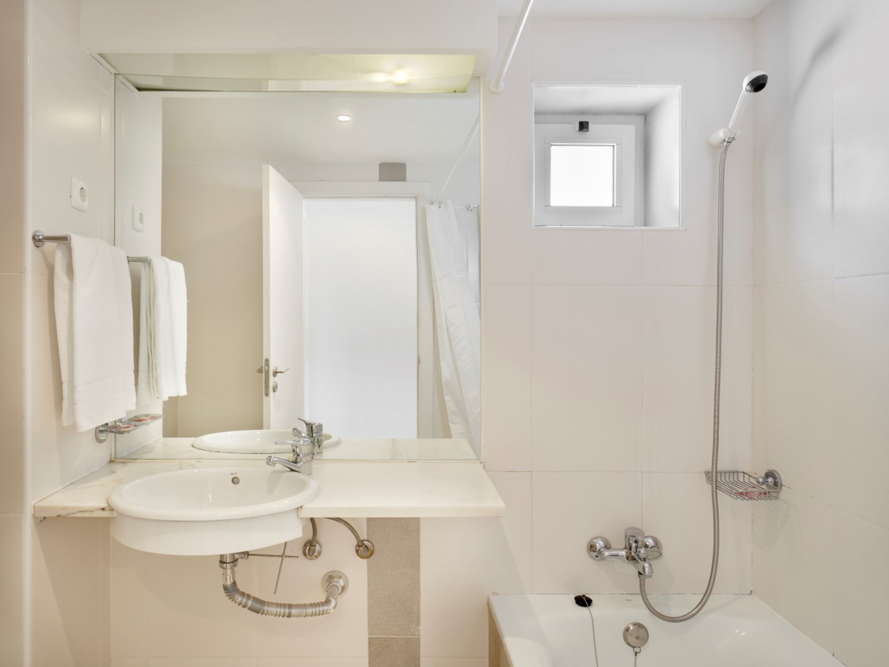 Ein modernes Badezimmer mit Waschbecken, Spiegel und Dusche.