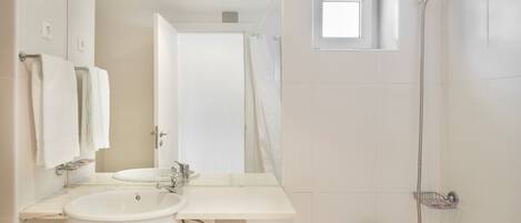 Ein modernes Badezimmer mit Waschbecken, Spiegel und Dusche.