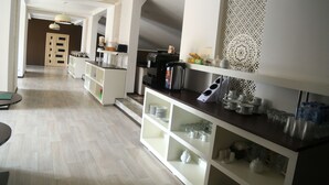Eine moderne Küche mit weißen Schränken, einer Kaffeemaschine und einer dekorativen Wandverkleidung.