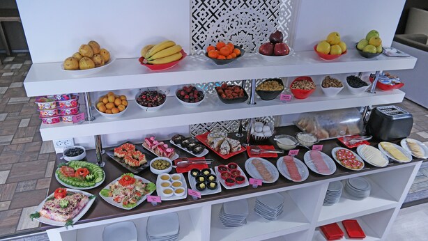 Ein Buffet mit verschiedenen Speisen und Beilagen, ansprechend auf mehreren Etagen angeordnet.