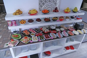 A buffet with various food items and condiments arranged on multiple shelves. - Rohat Hotel (Dushanbe)