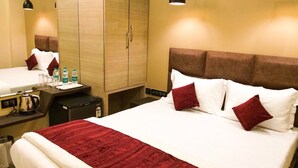 A hotel room with a bed, bedside table, and a wardrobe. - The Fountain Inn - Fort (Mumbai)