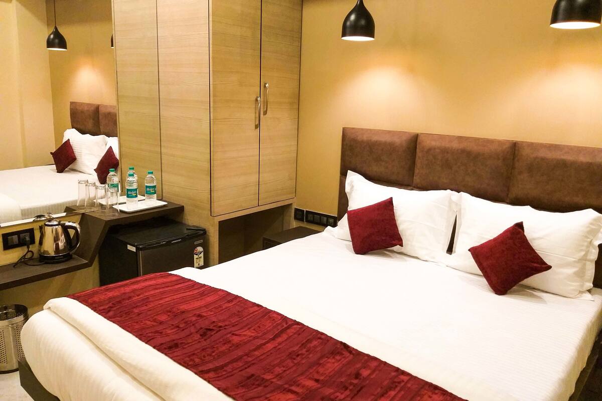 A hotel room with a bed, bedside table, and a wardrobe.