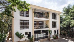 A multi-story building with balconies, large windows, and potted plants. - Lenana Suites (Nairobi)