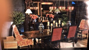 Un comedor con una mesa de madera, sillas y velas.