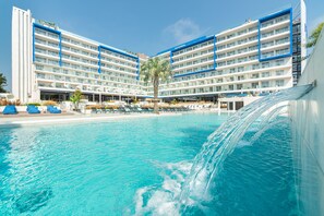 Un hotel con varios pisos, piscina y una cascada.