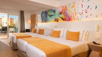 Habitación de hotel con dos camas, un cuadro abstracto de colores en la pared y vista a la ciudad desde la ventana.