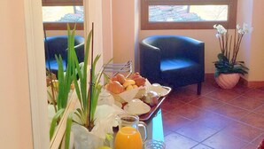 Un bufé de desayuno con diversas opciones de comida y una planta en maceta.