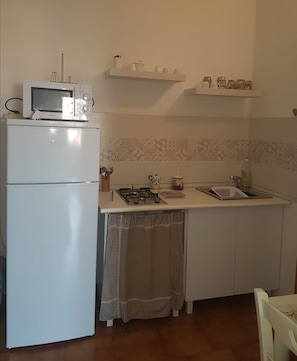 Full-size fridge, microwave, stovetop, cookware/dishes/utensils