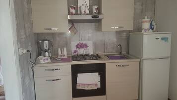 Chambre Triple Classique, balcon | Coin cuisine privé | Grand réfrigérateur, micro-ondes dans l'espace commun, plaque de cuisson