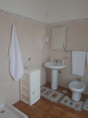 Habitación triple clásica, balcón | Baño | Amenidades de baño gratuitas, secadora de cabello, bidet, toallas