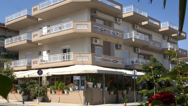 A multi-story hotel with balconies, outdoor seating, and potted plants. - Harisis Apartments (Katerini)