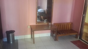A room with a wooden bench, a table, and a mirror on the wall. - Hotel Sinchula (Phuntsholing)
