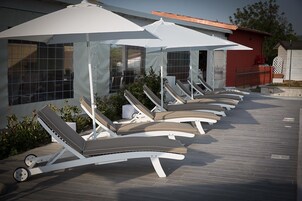 Una piscina al aire libre de temporada, sombrillas, tumbonas