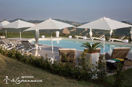 Una piscina al aire libre de temporada, sombrillas