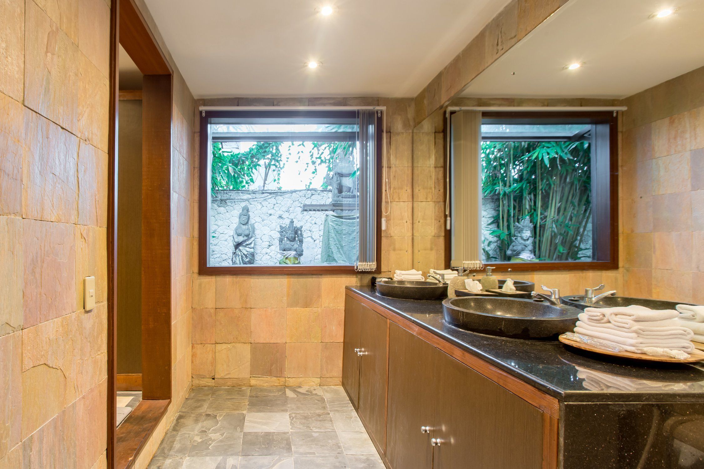 A modern bathroom with a large window, a sink, and a mirror.