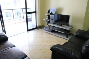 Apartamento, várias camas, para não fumantes | Sala de estar | TV de tela plana
