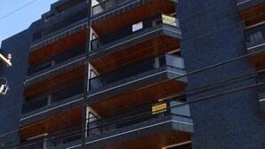 Ein mehrgeschossiges Wohngebäude mit Balkonen, einer Treppe zum Eingang und einem Schild mit der Adresse 'Residential Barramare 450'.