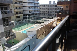 A residential building with multiple balconies, a rooftop pool, and a staircase leading to the upper floors.