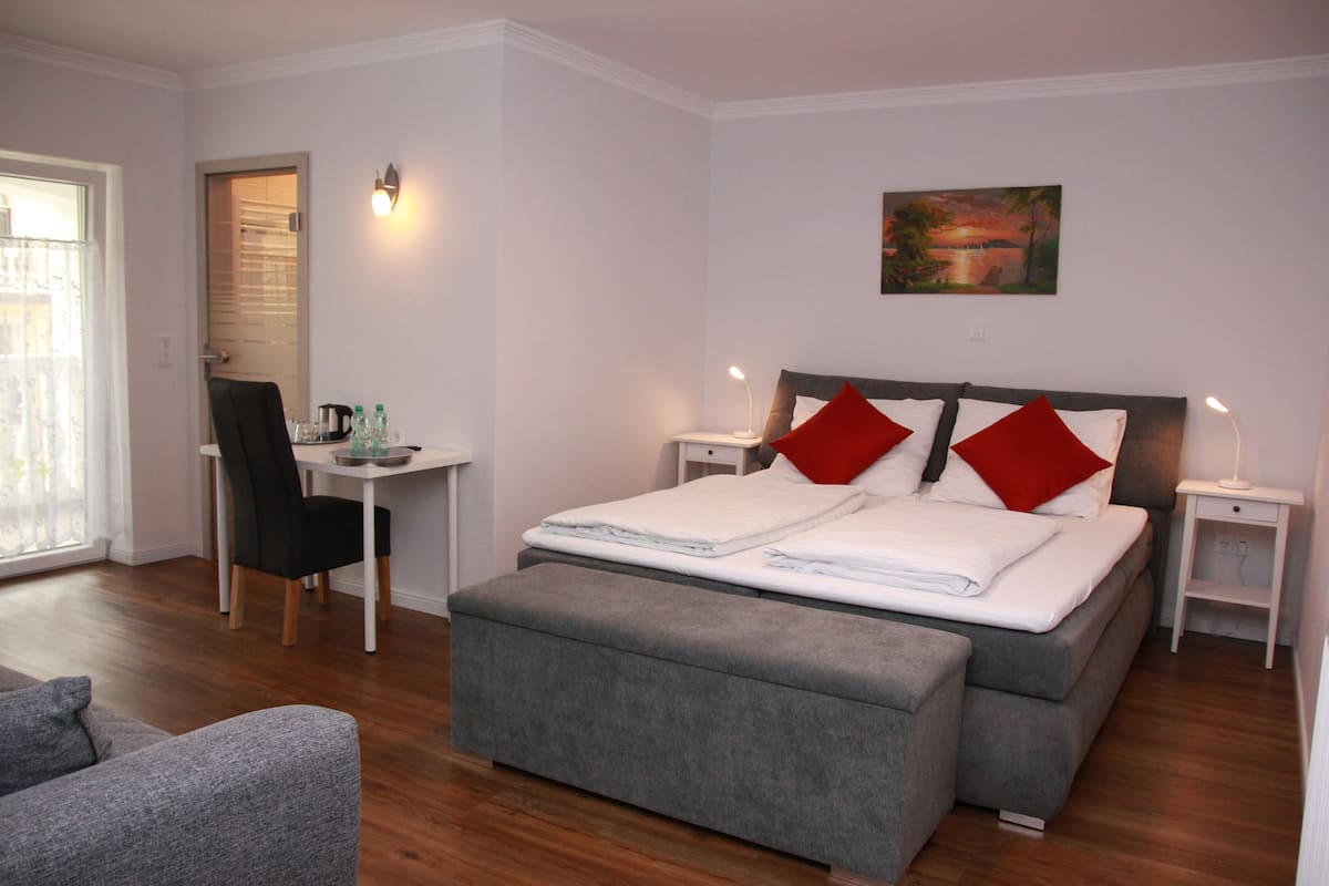 A bedroom with a bed, a desk, and a chair.