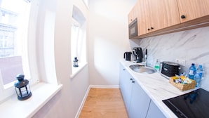 Una cocina compacta con ventana, microondas, tostadora y lavamanos.